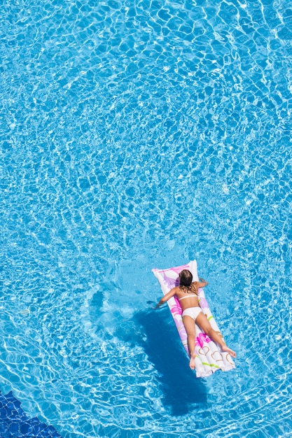 Vista dall&#39;alto della donna in piscina con materassino