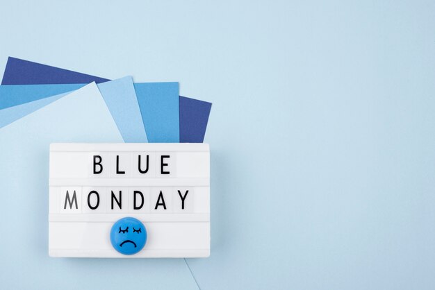 Vista dall'alto della faccia triste con carta e scatola luminosa per il lunedì blu