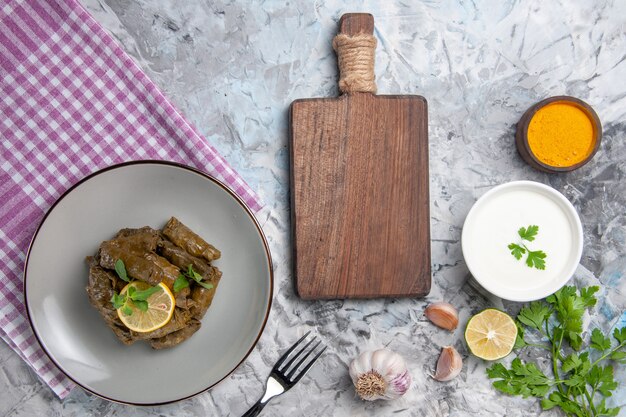 Vista dall'alto della gustosa foglia dolma con aglio e yogurt sulla superficie bianca