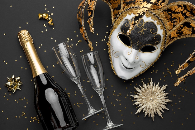 Vista dall'alto della maschera per il carnevale con glitter e bottiglia di champagne