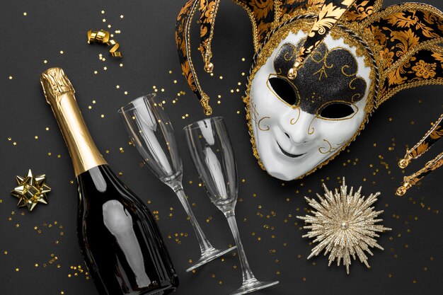 Vista dall'alto della maschera per il carnevale con glitter e bottiglia di champagne