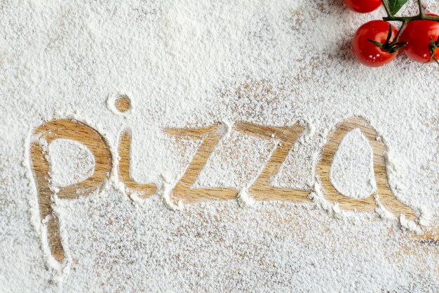 Vista dall'alto della parola pizza scritta nella farina