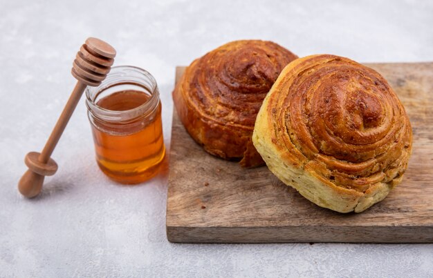 Vista dall'alto della pasticceria tradizionale azera gogal su una tavola da cucina in legno con miele su un vasetto di vetro su sfondo bianco