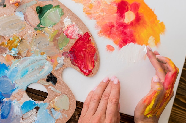 Vista dall'alto della pittura dell'artista usando le mani