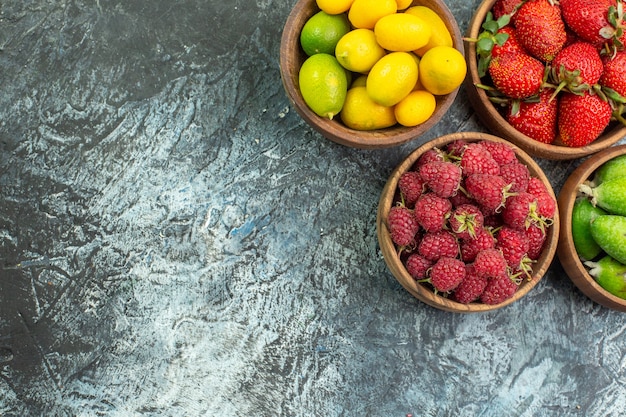 Vista dall'alto della raccolta di frutta fresca in secchi sul lato sinistro su sfondo scuro