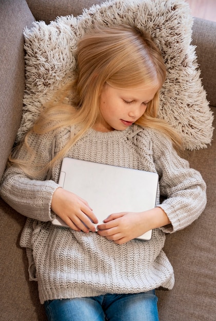 Vista dall'alto della ragazza che dorme con il tablet