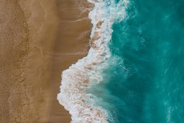 Vista dall'alto della sabbia che incontra l'acqua di mare