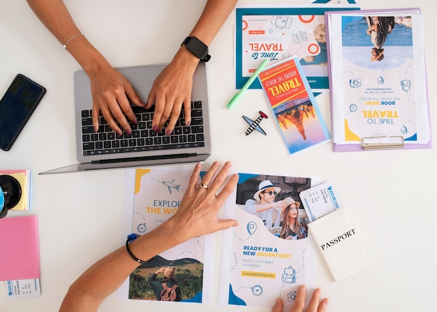 Vista dall'alto della scrivania dell'agenzia di viaggi con persone che lavorano sul laptop