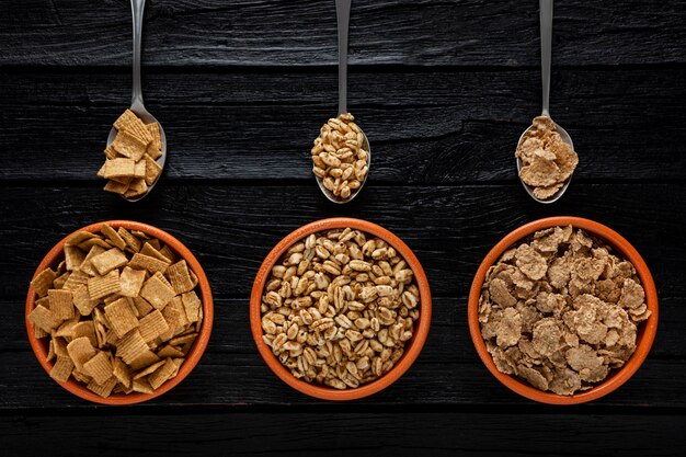 Vista dall'alto della selezione di cereali per la colazione in ciotole con cucchiai