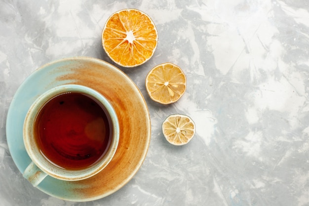 Vista dall'alto della tazza di tè al limone sulla superficie bianca