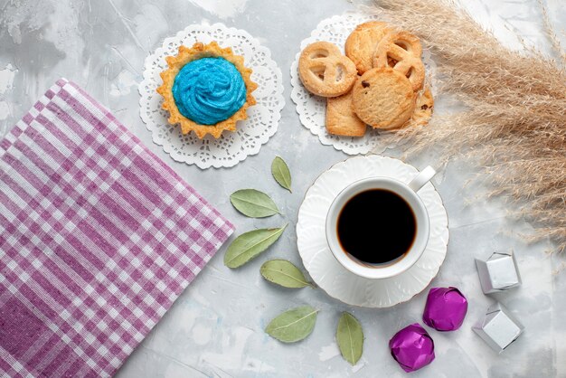 Vista dall'alto della tazza di tè con deliziosi biscotti al cioccolato caramelle sul pavimento leggero biscotto biscotto tè dolce