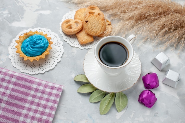 Vista dall'alto della tazza di tè con deliziosi biscotti al cioccolato caramelle sulla scrivania leggera, biscotto biscotto caramelle chocoalte