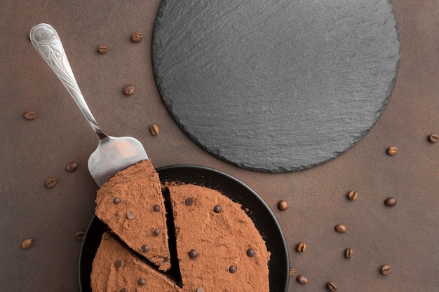 Vista dall'alto della torta al cioccolato con cacao in polvere e chicchi di caffè