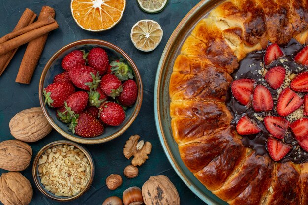 Vista dall'alto della torta di fragole con noci e bastoncini di cannella