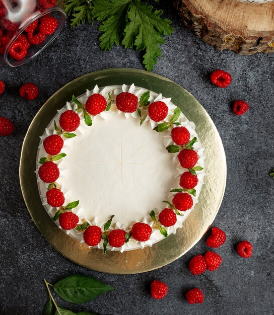 Vista dall'alto della torta di lamponi decorata con lamponi crema bianco e foglie di menta