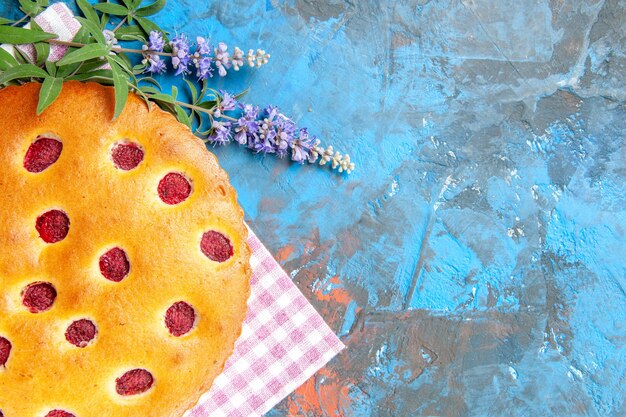 Vista dall'alto della torta di lamponi su carta da cucina sulla superficie blu