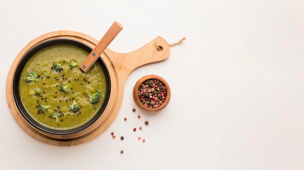 Vista dall'alto della zuppa di broccoli invernali in una ciotola con cucchiaio e copia spazio