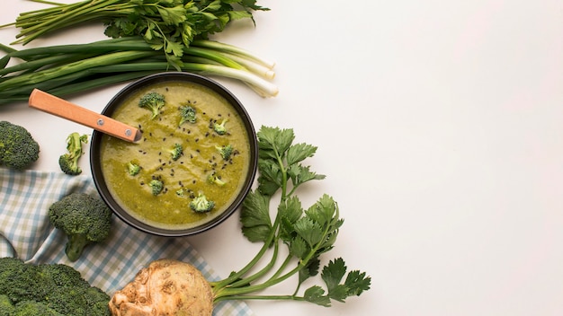 Vista dall'alto della zuppa di broccoli invernali in una ciotola con sedano e copia spazio