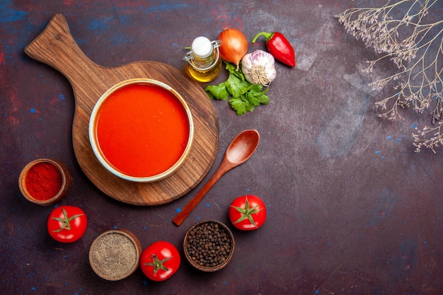 Vista dall'alto della zuppa di pomodoro con condimenti su nero