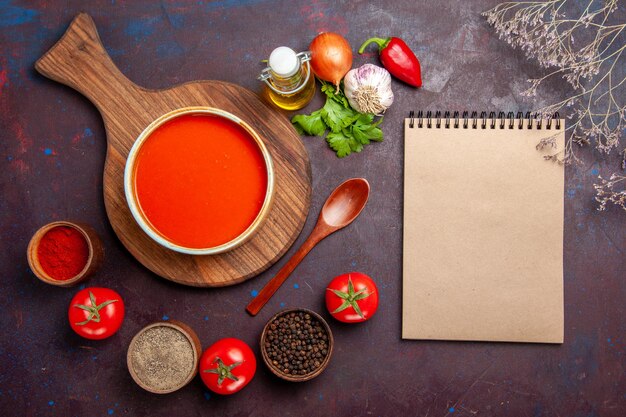 Vista dall'alto della zuppa di pomodoro con condimenti su nero