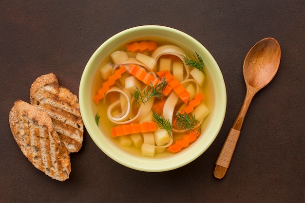 Vista dall'alto della zuppa di verdure invernali con pane tostato e cucchiaio
