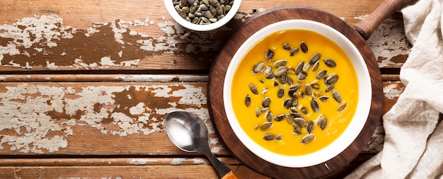 Vista dall'alto della zuppa di zucca autunnale con semi e copia spazio