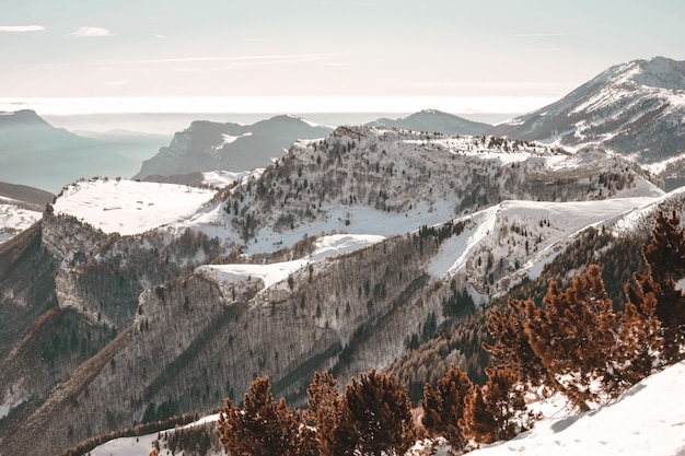 Vista dall'alto delle montagne innevate sotto il cielo blu chiaro