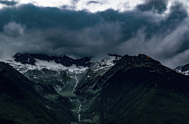 Vista dall'alto delle montagne sotto il cielo nuvoloso grigio