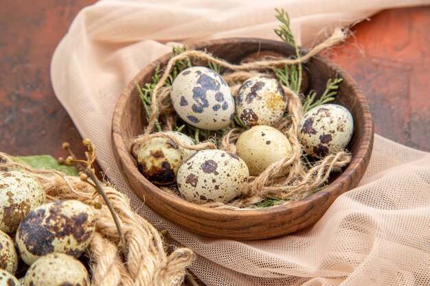 Vista dall'alto delle uova fresche di fattoria su un rotolo di corda sulla borsa e su una pentola su un tavolo marrone