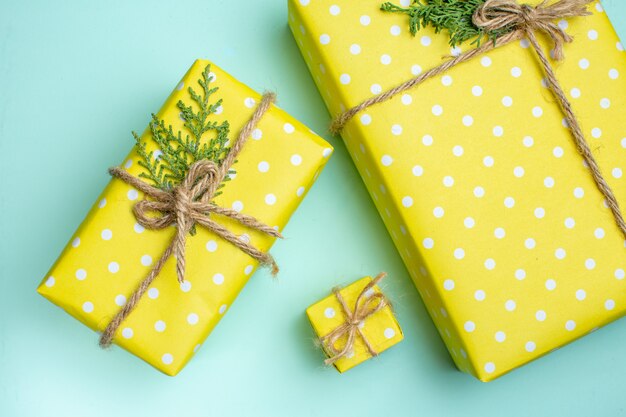 Vista dall'alto dello sfondo di Natale con scatole regalo gialle di diverse dimensioni su sfondo verde pastello