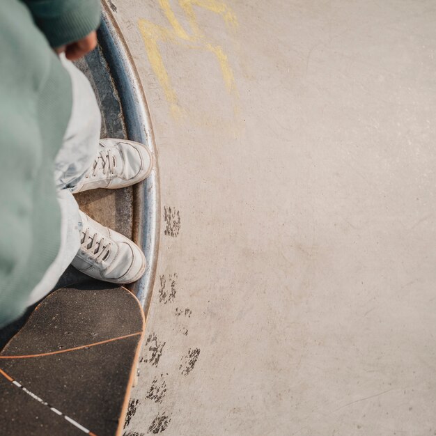 Vista dall'alto di adolescente con skateboard e copia spazio