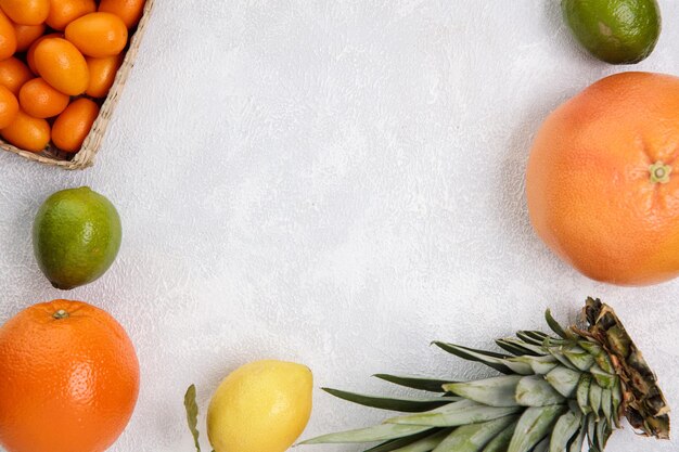 Vista dall'alto di agrumi come pompelmo mandarino kumquat lime limone arancia su sfondo bianco con spazio per la copia