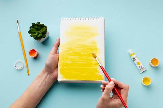 Vista dall'alto di aquarelle giallo su notebook