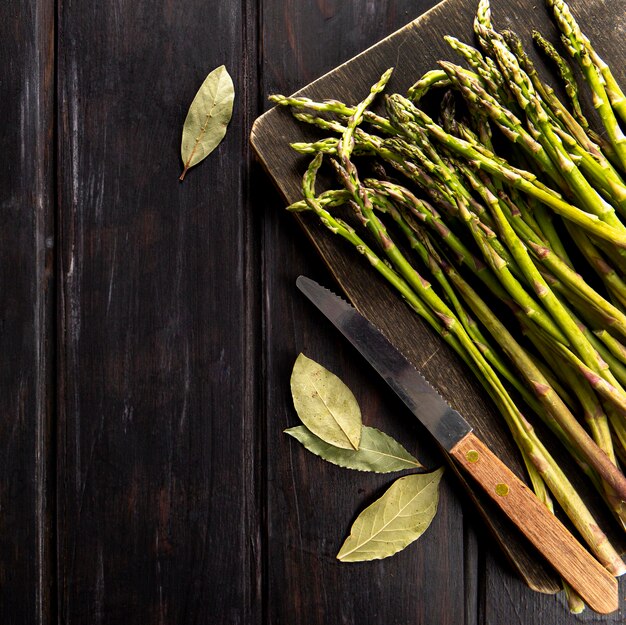 Vista dall'alto di asparagi con coltello e foglie di alloro