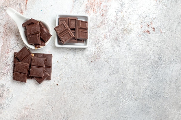 Vista dall'alto di barrette di cioccolato sulla superficie bianca