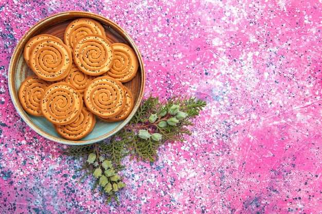 Vista dall'alto di biscotti dolci sulla superficie rosa chiaro