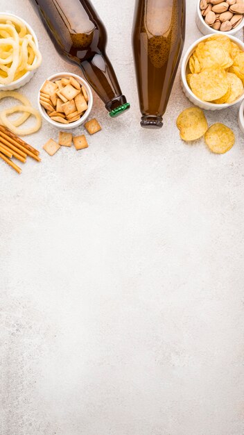 Vista dall'alto di bottiglie di birra e cornice di snack