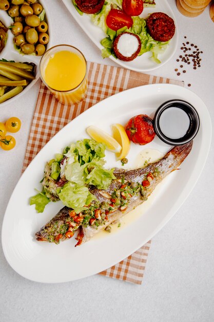 Vista dall'alto di branzino alla griglia con insalata fresca