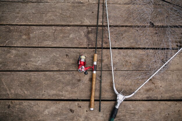 Vista dall&#39;alto di canna da pesca e rete sul molo di legno