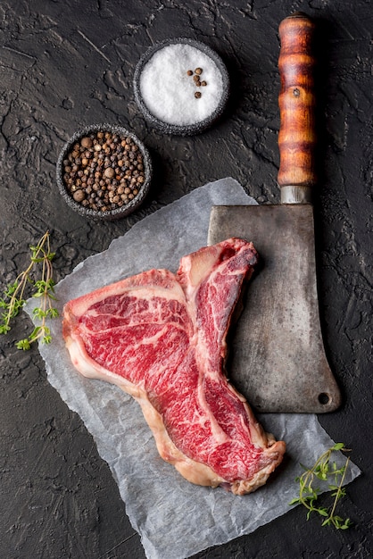 Vista dall'alto di carne con sale e spezie su ardesia