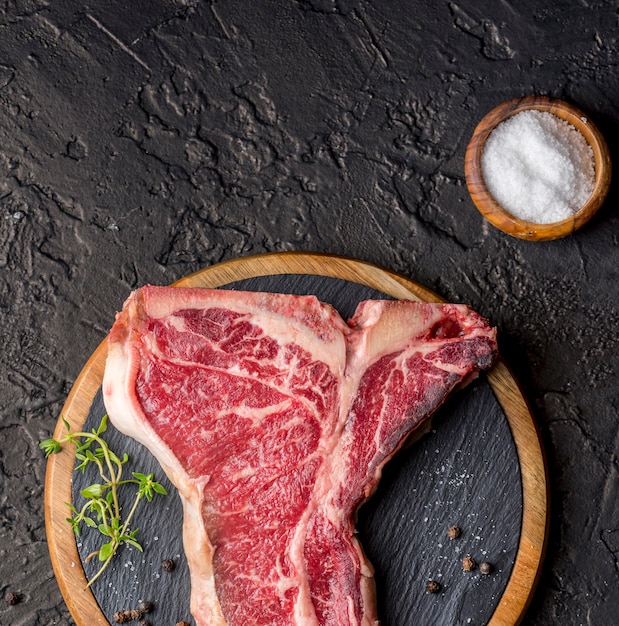 Vista dall'alto di carne con sale su ardesia