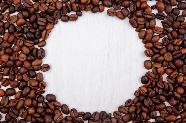 Vista dall'alto di chicchi di caffè freschi isolati su uno sfondo bianco con spazio di copia