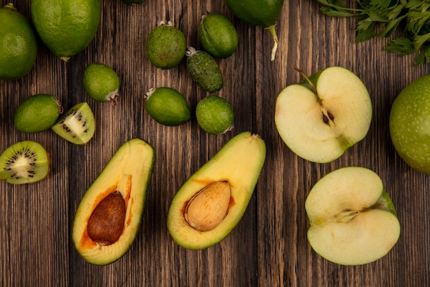 Vista dall'alto di cibo verde fresco come mele avocado feijoas e limette isolato su uno sfondo di legno