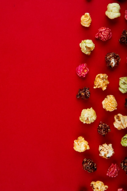 Vista dall'alto di cioccolato e birilli popcorn sul lato destro e rosso con spazio di copia