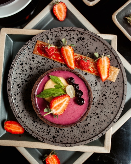 Vista dall'alto di crostata di bacche decorata con uva fragola e pesca