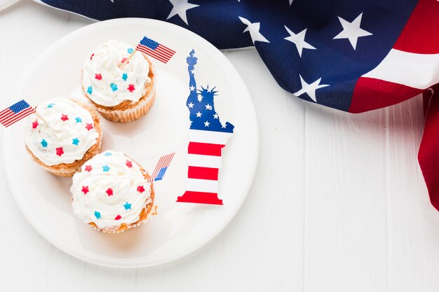 Vista dall'alto di cupcakes sul piatto con la statua della libertà e bandiere americane