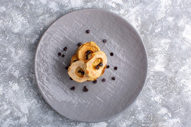 Vista dall'alto di deliziose fette di torta all'interno del piatto con choco chips sulla superficie grigio-chiara