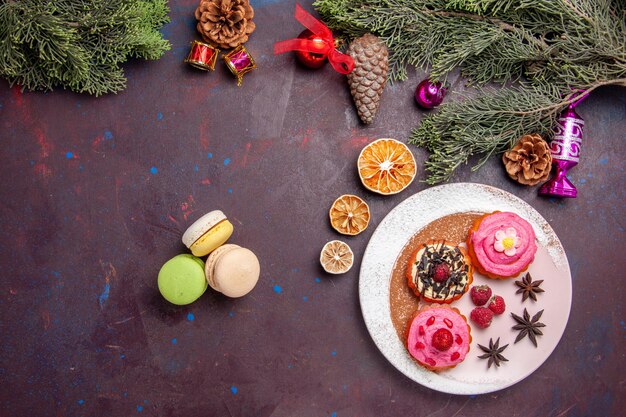 Vista dall'alto di deliziose torte con macarons francesi su nero