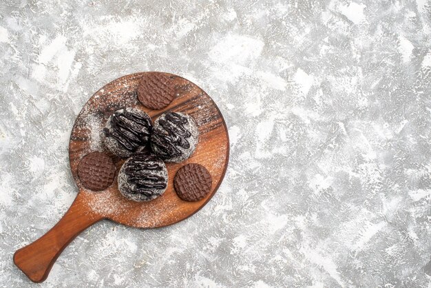 Vista dall'alto di deliziose torte di palline di cioccolato con i biscotti sulla superficie bianca