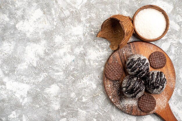 Vista dall'alto di deliziose torte di palline di cioccolato con i biscotti sulla superficie bianca